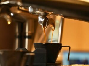 A freshly brewed cup of specialty coffee with roasted coffee beans, showcasing the rich aroma and unique flavours that distinguish specialty coffee from regular coffee.
